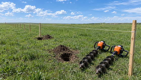 The staked fence line at noon with two augers